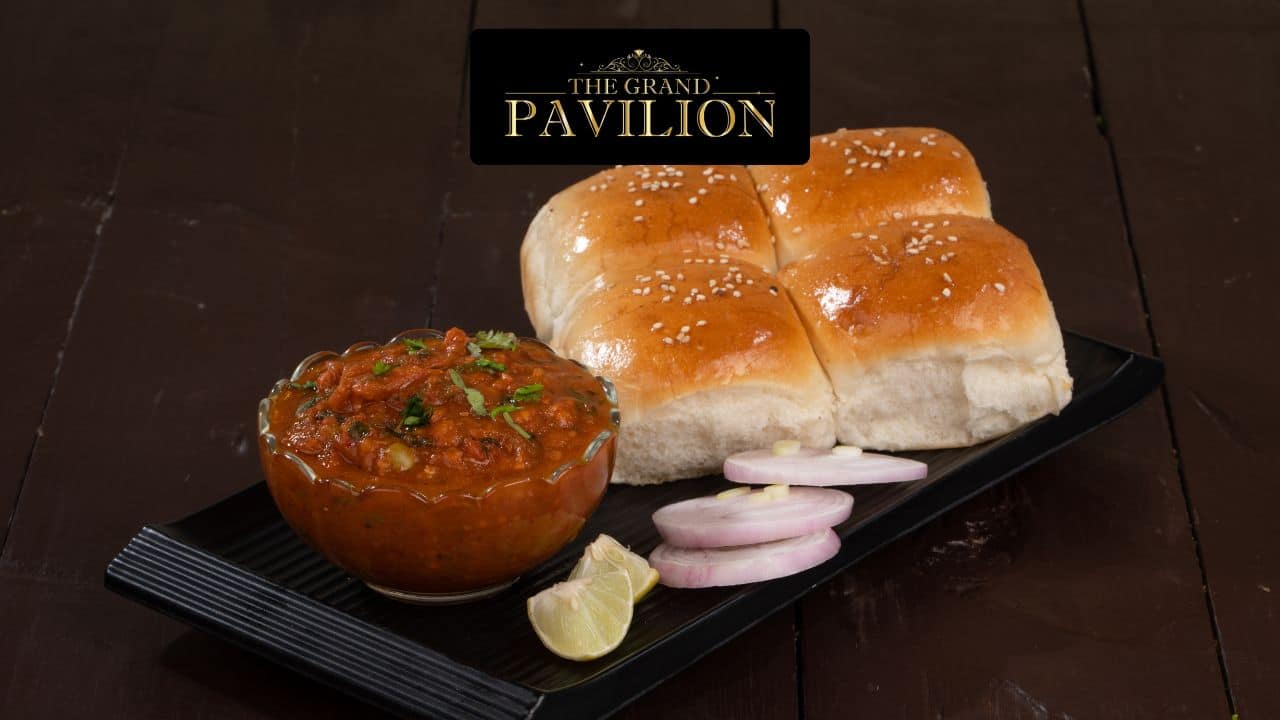 Steamed bread rolls with spicy curry, onions, lemon on black plate at The Grand Pavilion.