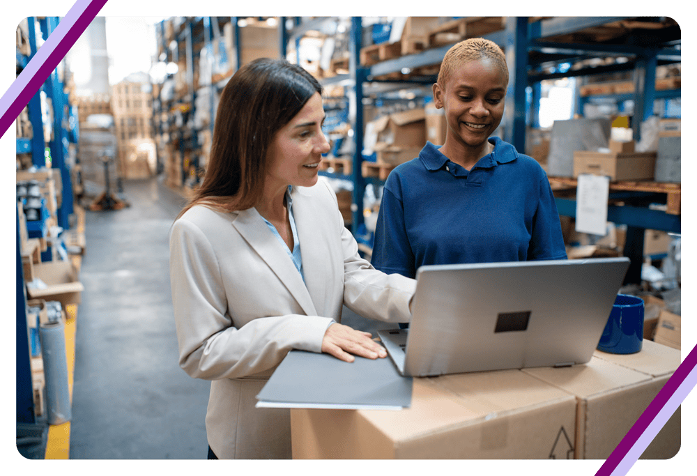 Two women working in a warehouse with laptop
