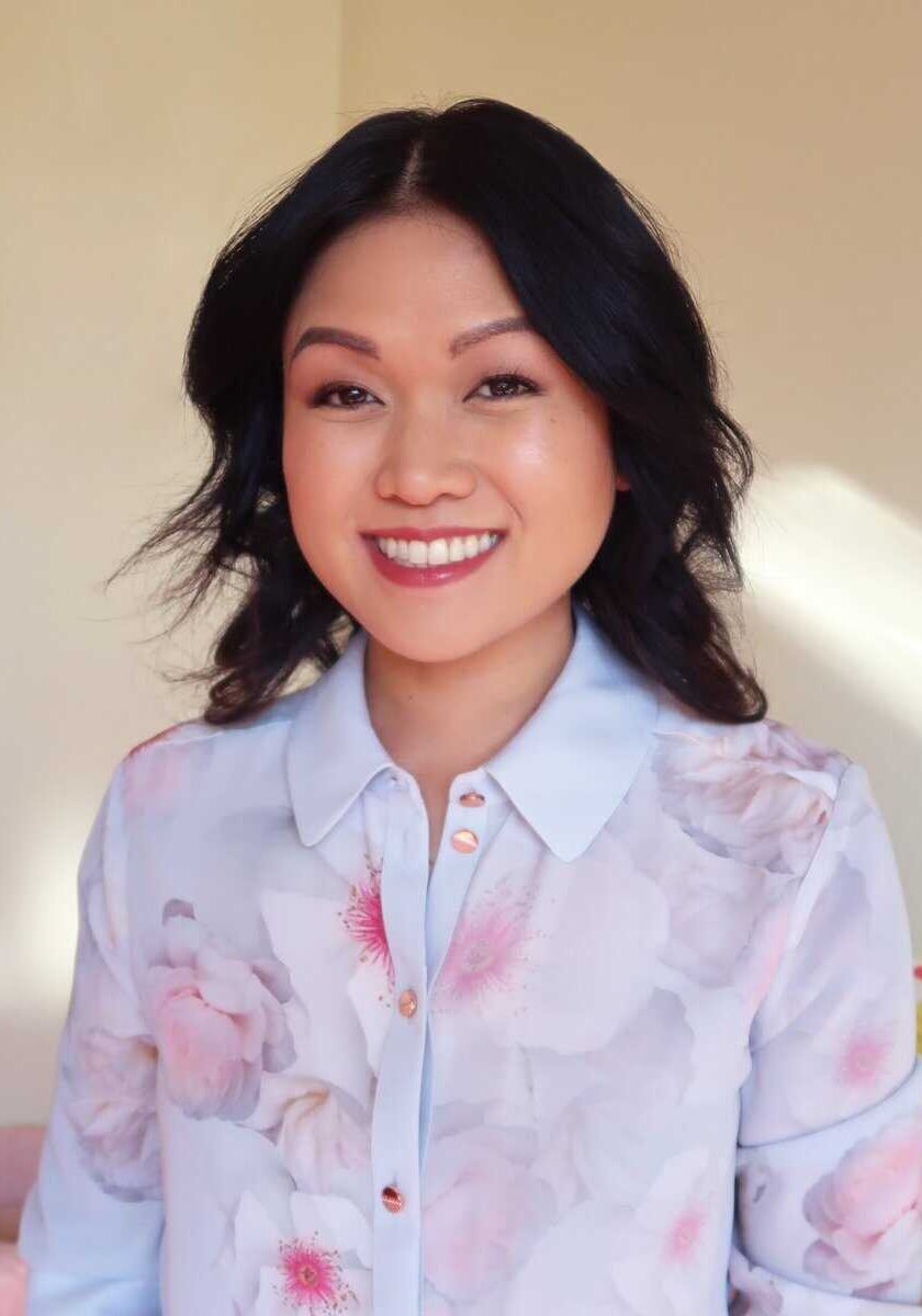 Aireen Arellano Smiling woman in floral blouse indoors.
