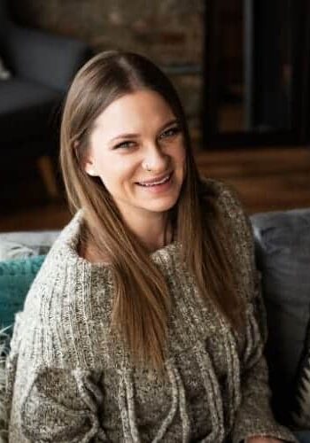 Christina Sterzel Smiling person sitting on a cozy couch.