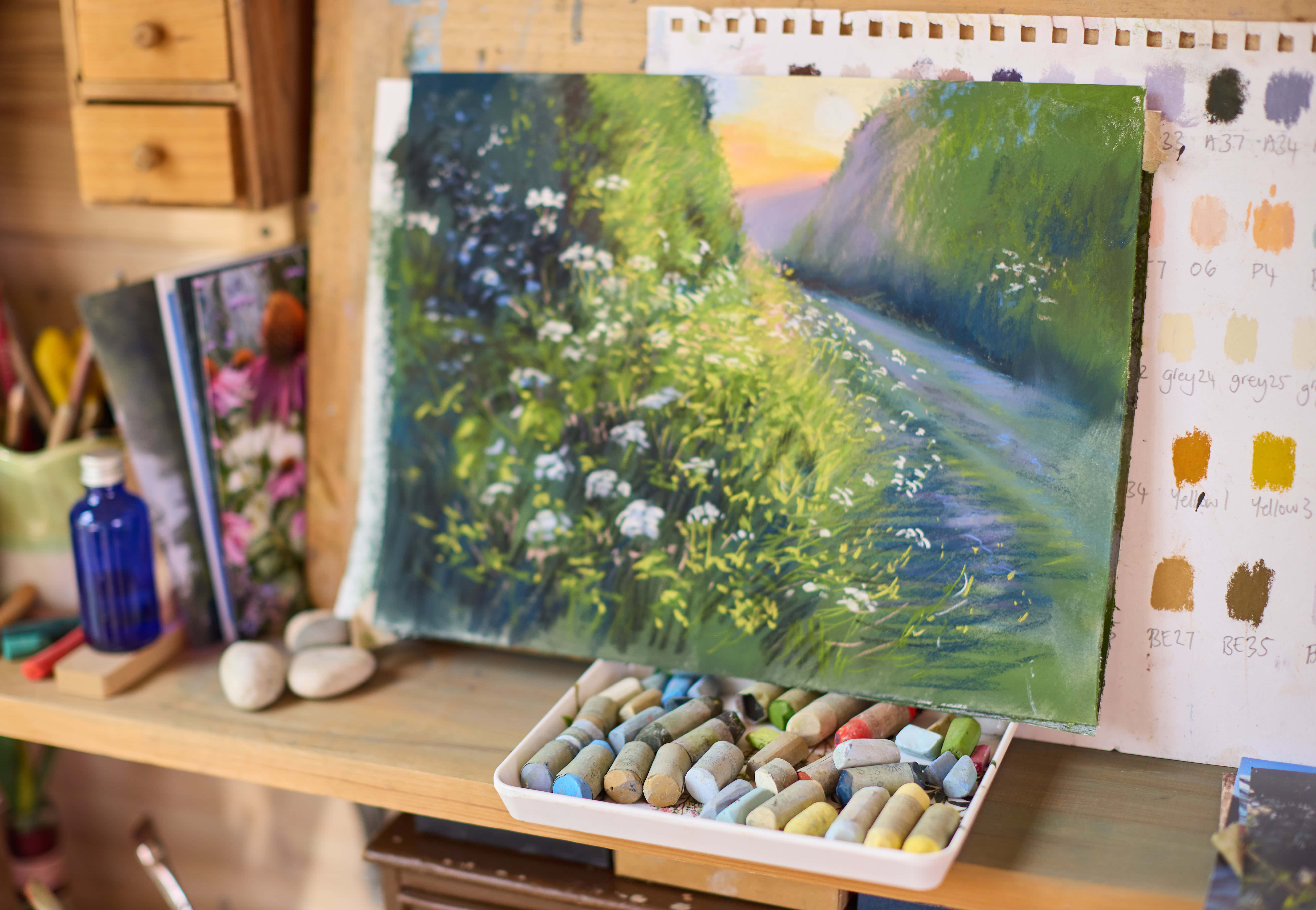 Pastel landscape painting by Nina Squire featuring a lush green path and white flowers.