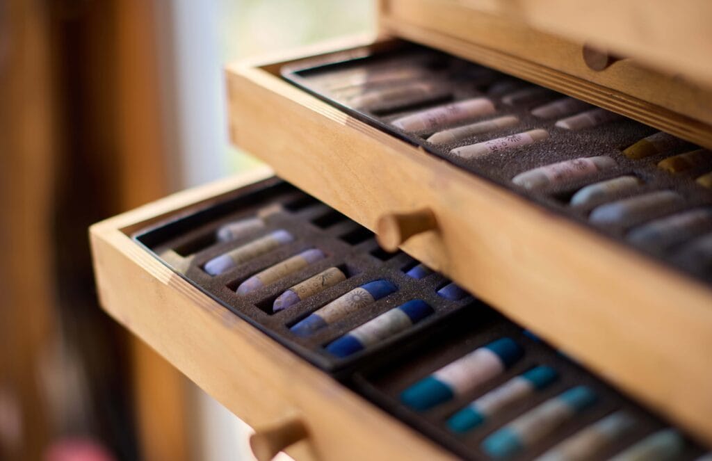Pastel art supplies in wooden drawers by Nina Squire.