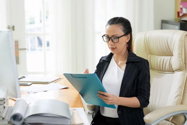 Business woman reviewing documents at desk.