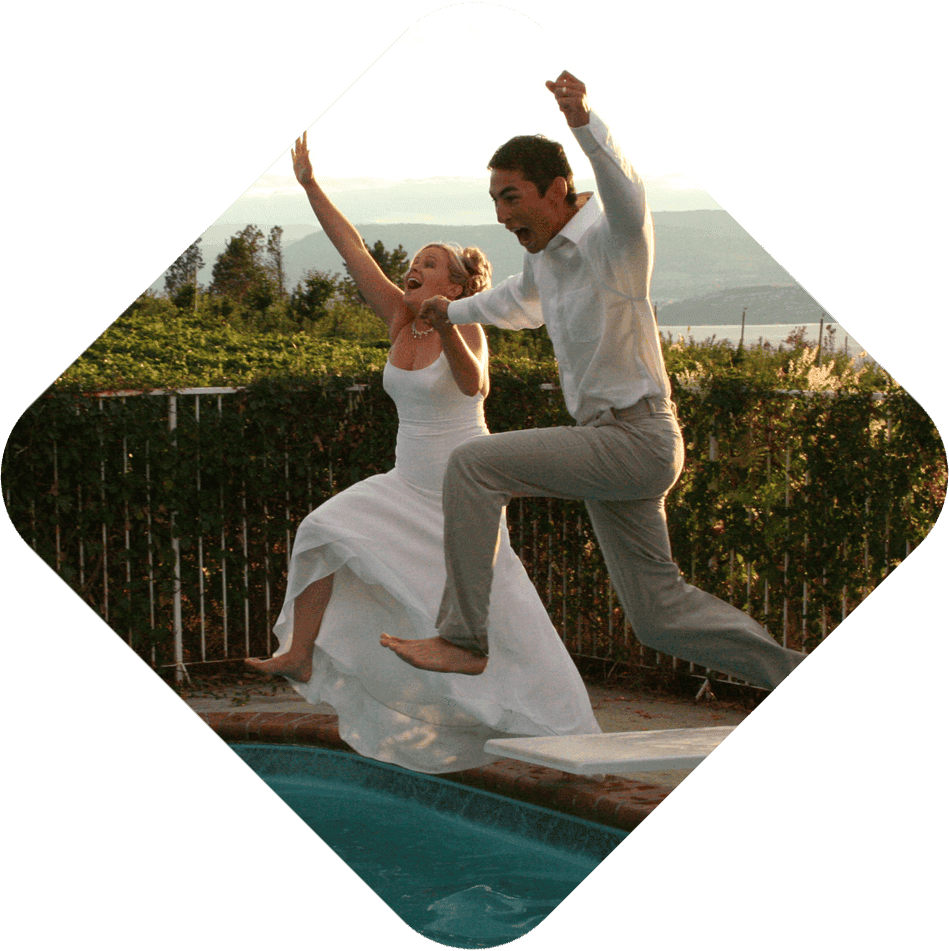 Bride and groom jumping into pool
