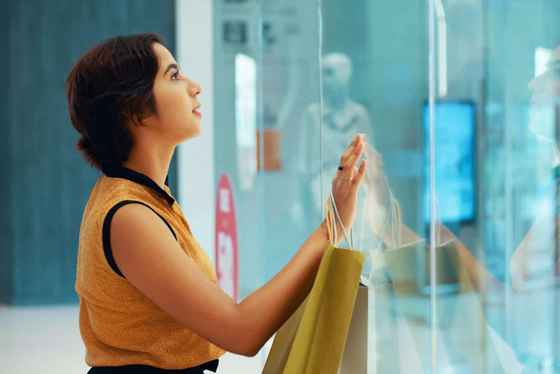 Young woman watching clothes in window case