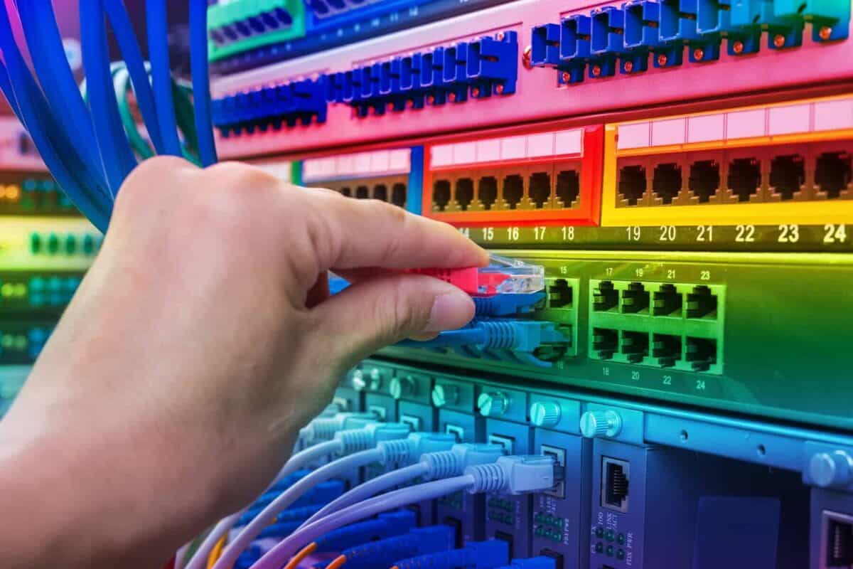 man working in network server room with fiber optic hub for digi