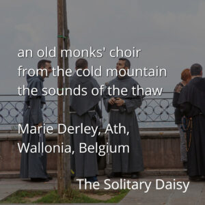 A group of monks in dark robes stand and converse by a railing outdoors under a cloudy sky. Text overlays the image with a poem and location details.