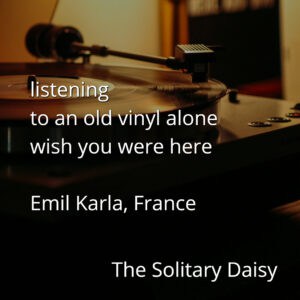 A close-up of a vinyl record player with text overlayed: a short poem expressing solitude and longing, attributed to Emil Karla, France, and titled "The Solitary Daisy.