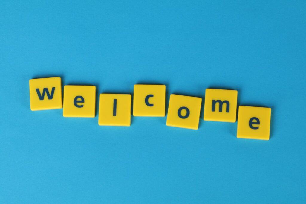 Yellow tiles spelling 'welcome' on a blue background, perfect for greetings.