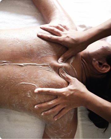 Woman receiving a back massage with massage lotion.