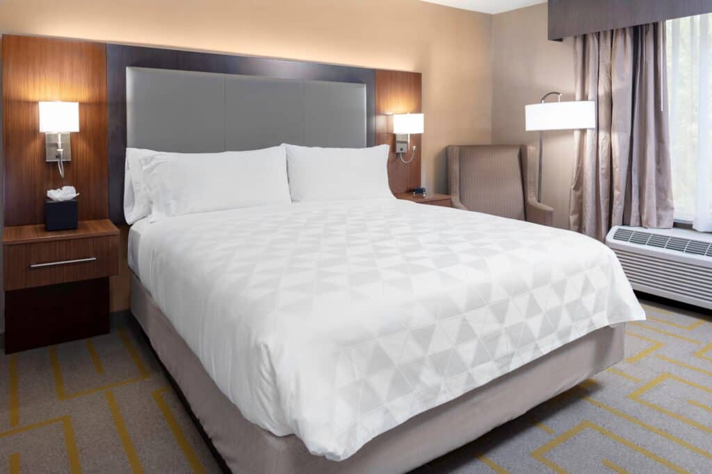 1 king bed room with a chair in the corner.