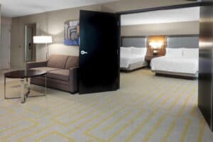 View of suite with sofa and two queen sized beds.