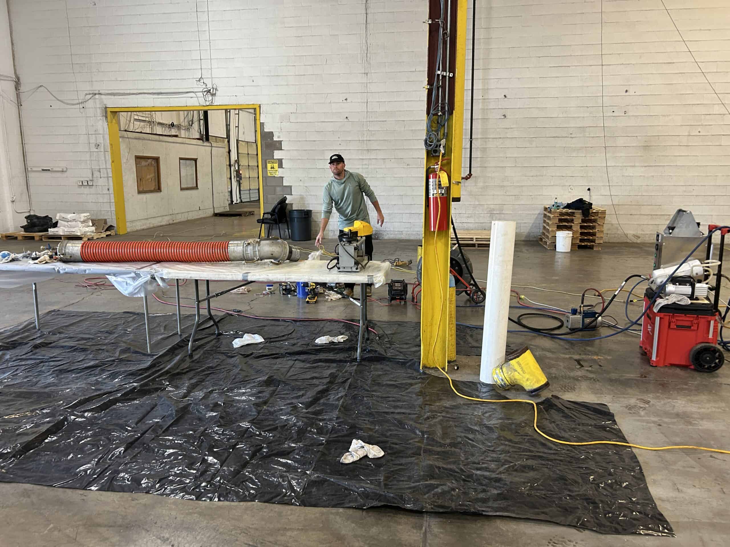 Technician performing hydro jetting for pipe cleaning and repair.