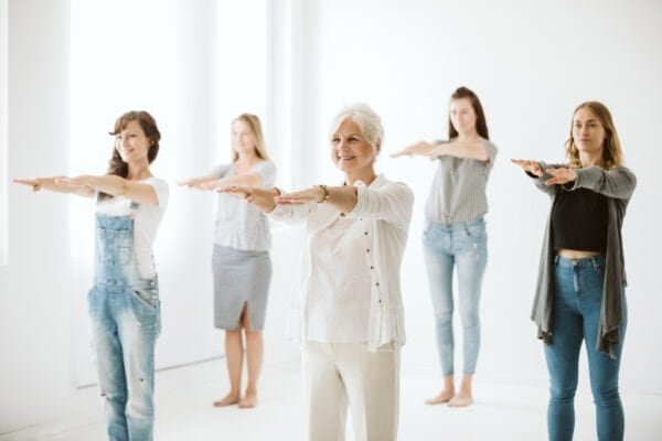 Five women in different age exercising together on a therapy