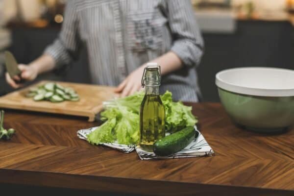 Young Woman Cooking in the kitchen. Healthy Food - Vegetable Salad. Diet. Dieting Concept. Healthy Lifestyle. Cooking At Home. Prepare Food