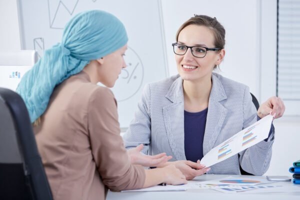 Smiling doctor showing a chart to her cancer patient
