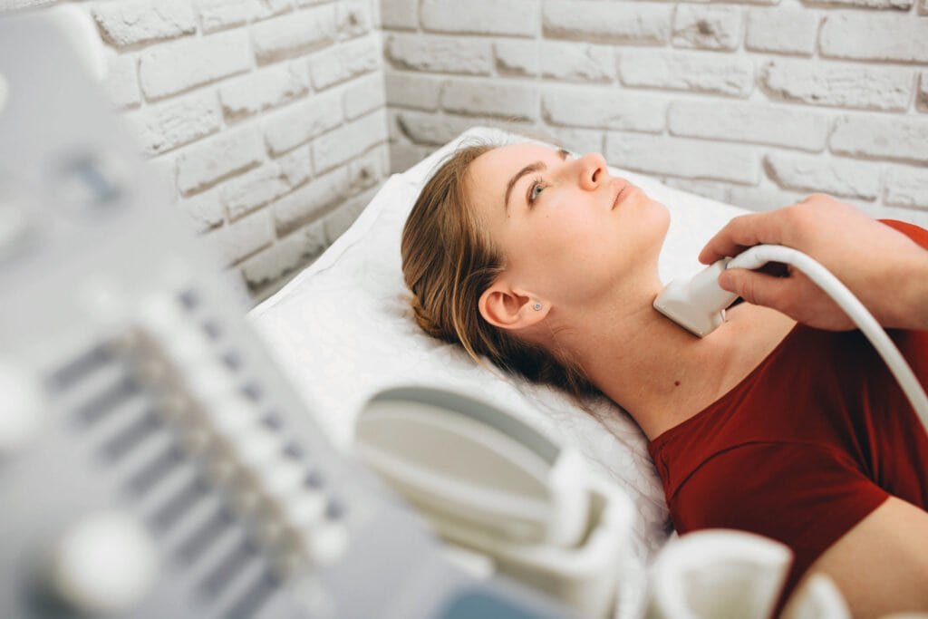 Female patient getting thyroid ultrasound exam in hospital