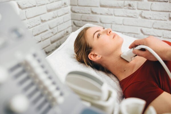 Female patient getting thyroid ultrasound exam in hospital