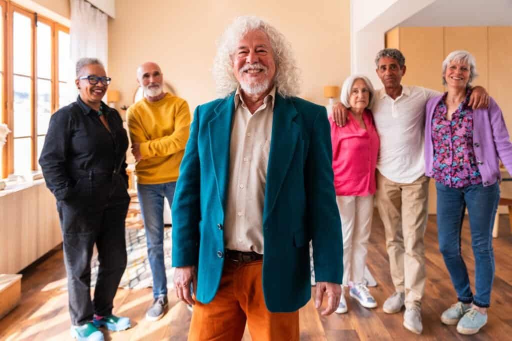 Group of happy senior friends bonding at home for dinner party - Cheerful and youthful old mature multiethnic people having fun