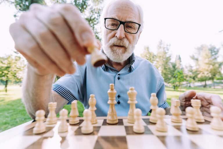Group of senior friends playing chess game at the park. Lifestyle concepts about seniority and third age