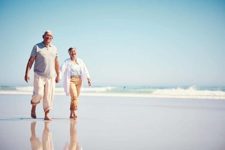 Holding hands, summer and an old couple walking on the beach with a blue sky mockup background. Lov.