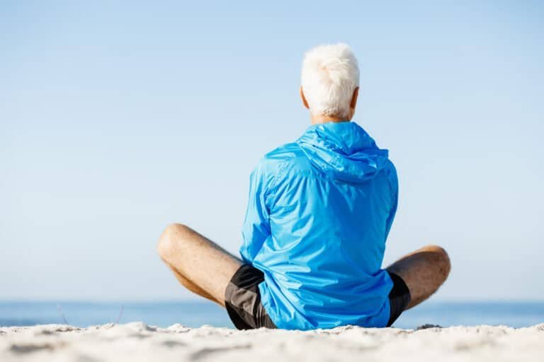 Handsome caucasian male doing exercises on beach