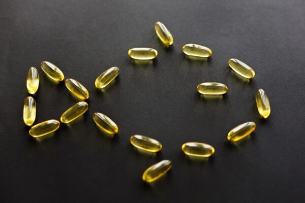 Omega 3 concept. Omega capsules in fish shape on black dark background. Fish oil pills. Dietary supplements. Health support and treatment. Biologically active additives.