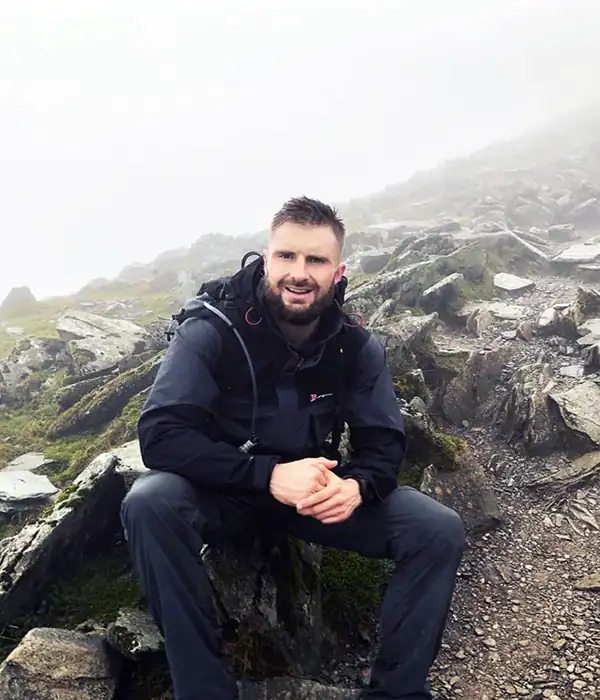 Man hiking on a rocky mountain trail.