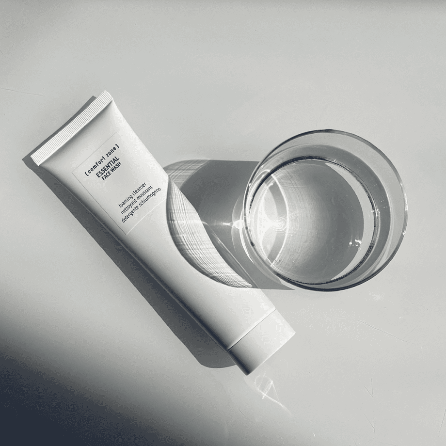 Tonic Day Spa essential face wash tube with glass of water, skincare product for cleansing.
