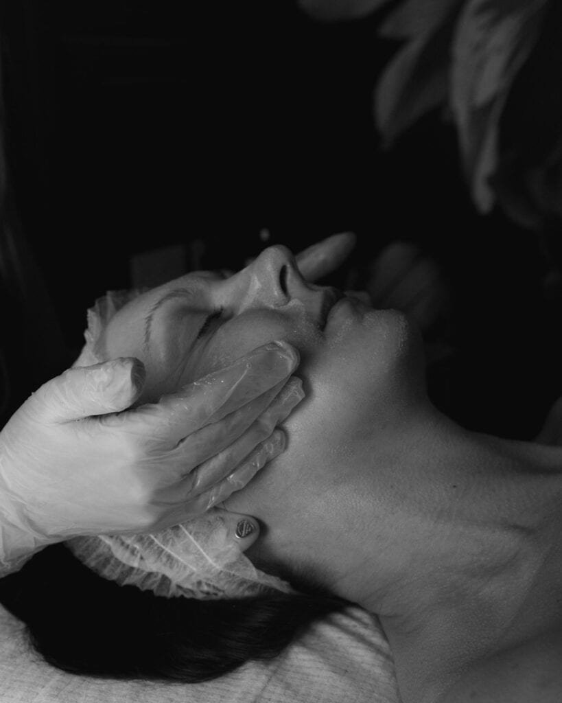 Relaxing chemical peel being applied to a woman's face for skin rejuvenation.