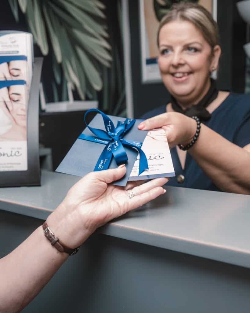 Woman receiving a spa gift voucher at Tonic Day Spa, perfect for pampering packages.