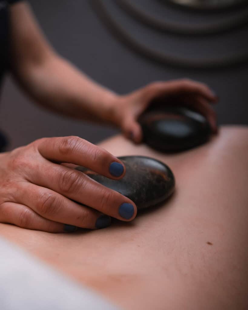 Hot stone massage therapy for stress relief and muscle relaxation at Tonic Day Spa. Experience sooth.