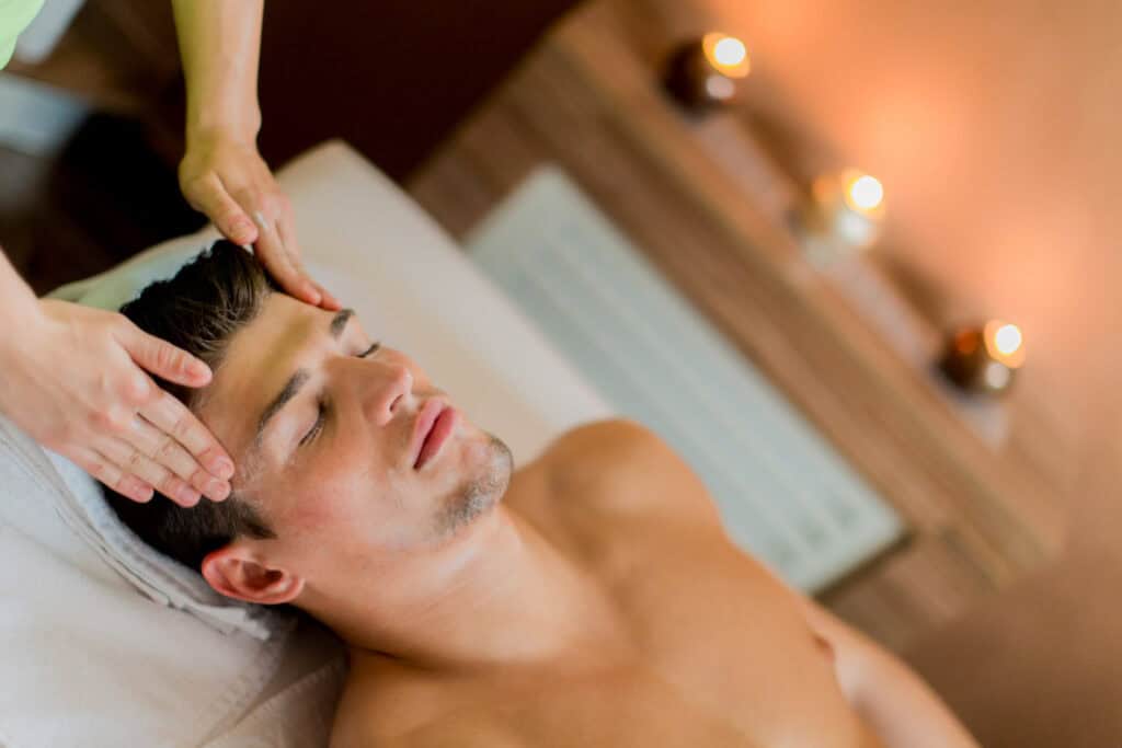 Man receiving a relaxing massage in a tranquil spa setting.