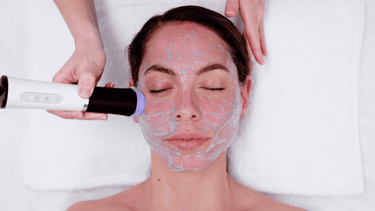 Woman receiving facial cleansing treatment with skincare device at Tonic Day Spa.