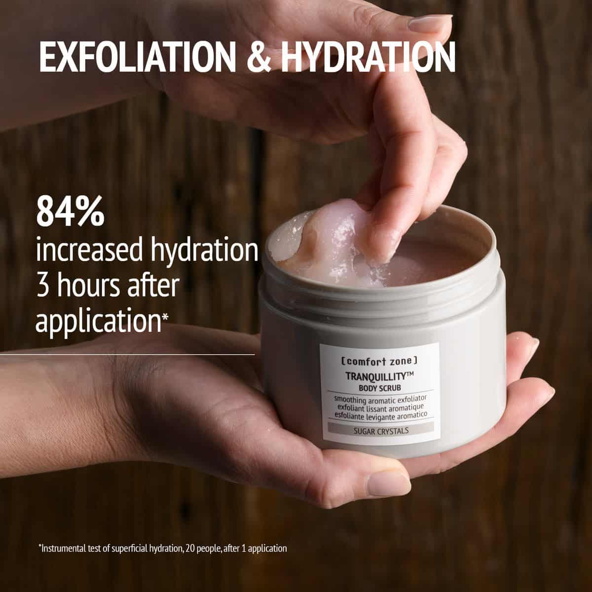 Hand applying Tranquillity Body Scrub for skin exfoliation and hydration.