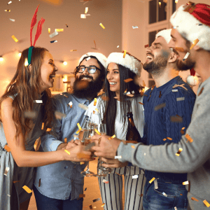 Joyful group celebrating with drinks and confetti at a festive party.