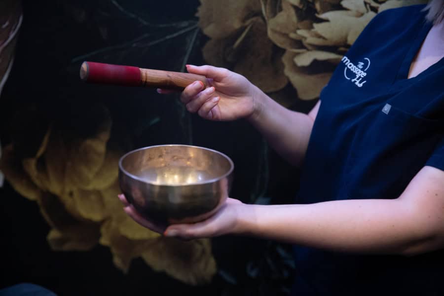 Photo of a therapist holding a Tibetan bowl we use in our Oncology treatments