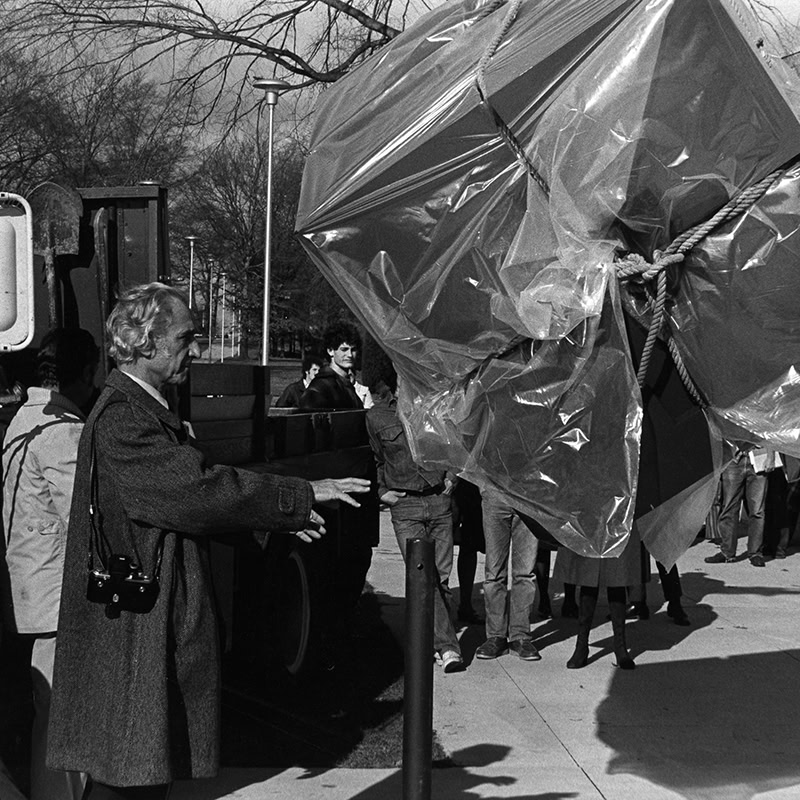 Black and white photo of Tony Rosenthal at the installation of the Astor Place "Alamo" Cube