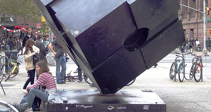 Person sitting on base of the Astor Place Cube