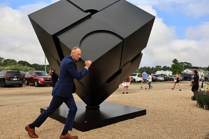 Dave Petrie, the director of the estate of the artist who created the Astor Place cube, gave it a spin at the Hamptons Fine Art Fair in Southampton, N.Y.Credit...James Barron/The New York Times