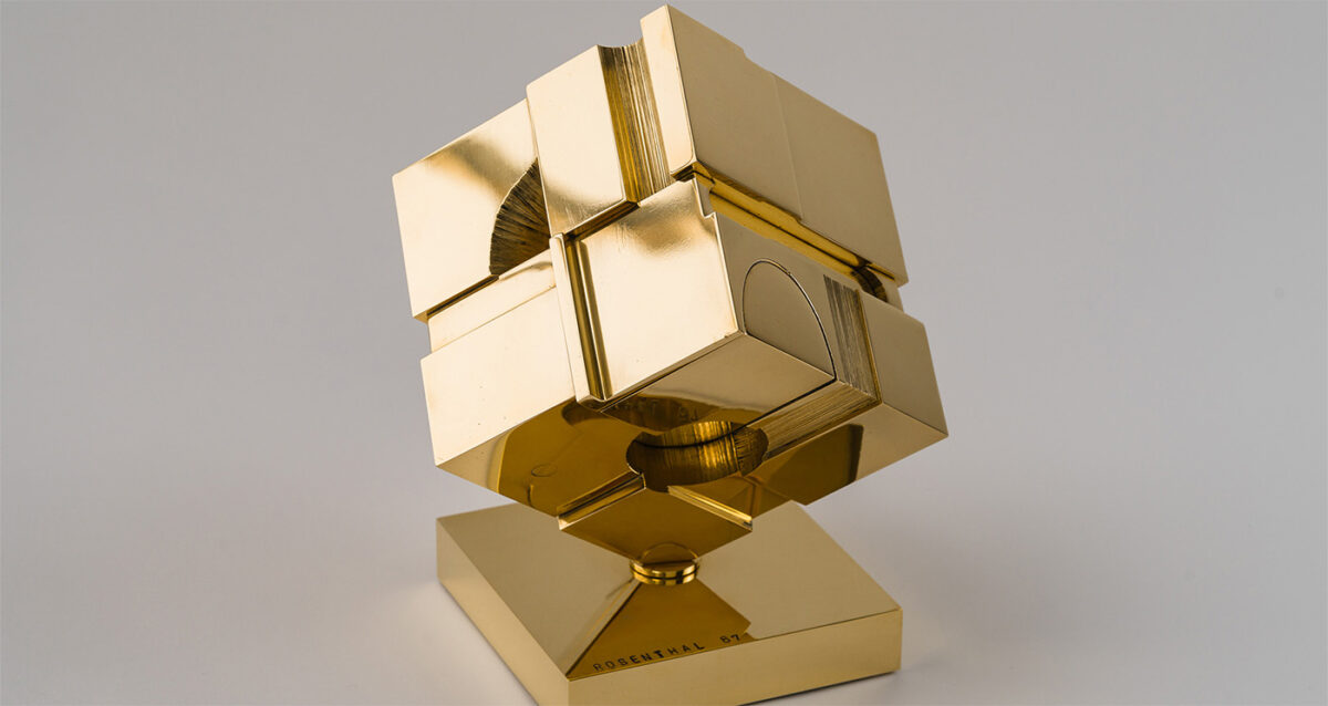 Elegant gold geometric sculpture by Tony Rosenthal, modern abstract art piece, polished metallic finish, contemporary decor, statement art for interior design.