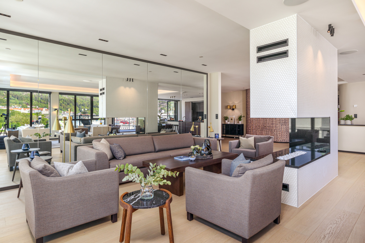 Modern hotel lounge with contemporary furniture, large windows, and scenic views of the surrounding landscape.