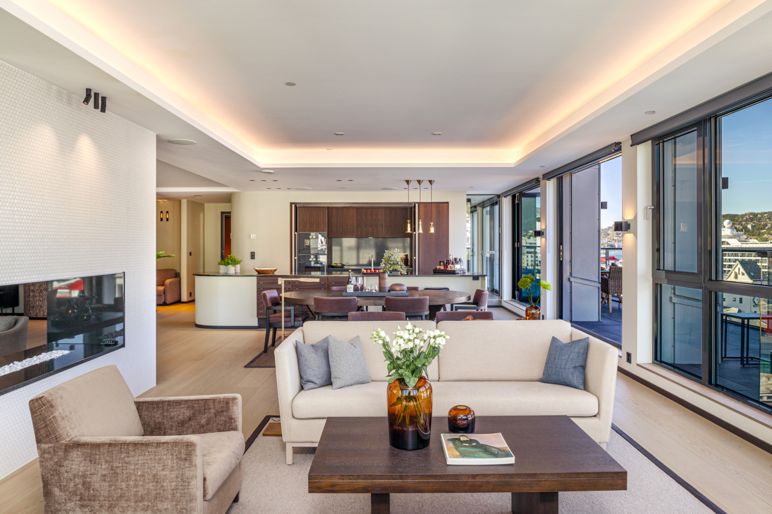 Bright modern living room with large windows and skyline views, open-concept design, stylish furniture, and cozy decor.