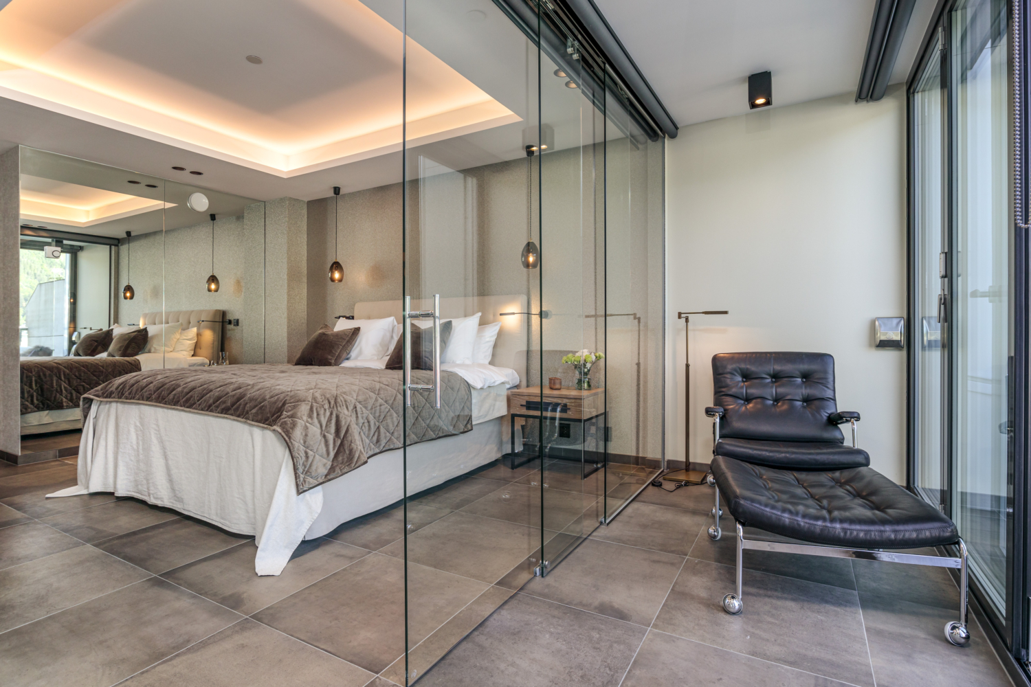Modern hotel bedroom with glass partition and stylish decor, ideal for a luxurious fjordside retreat.