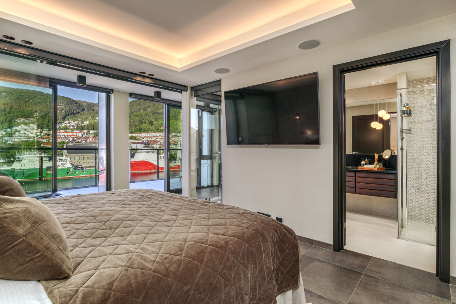 Luxurious bedroom with fjord view, modern decor, and private balcony in a top fjords hotel.