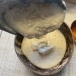 best bowl of rustic Scottish oatmeal porridge close up scoop on wooden spoon, bowl in background.