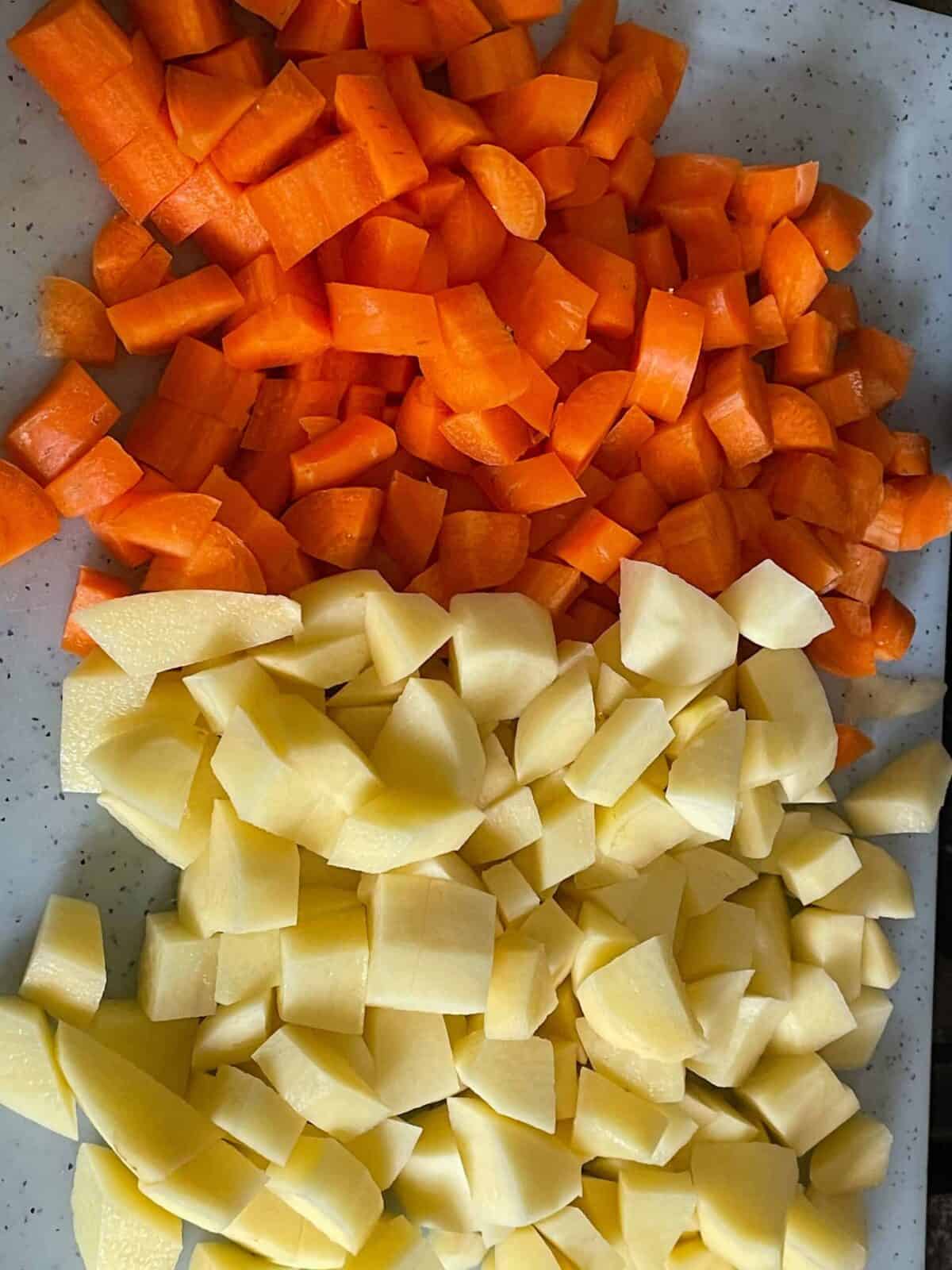Diced potato and carrot on cutting board.