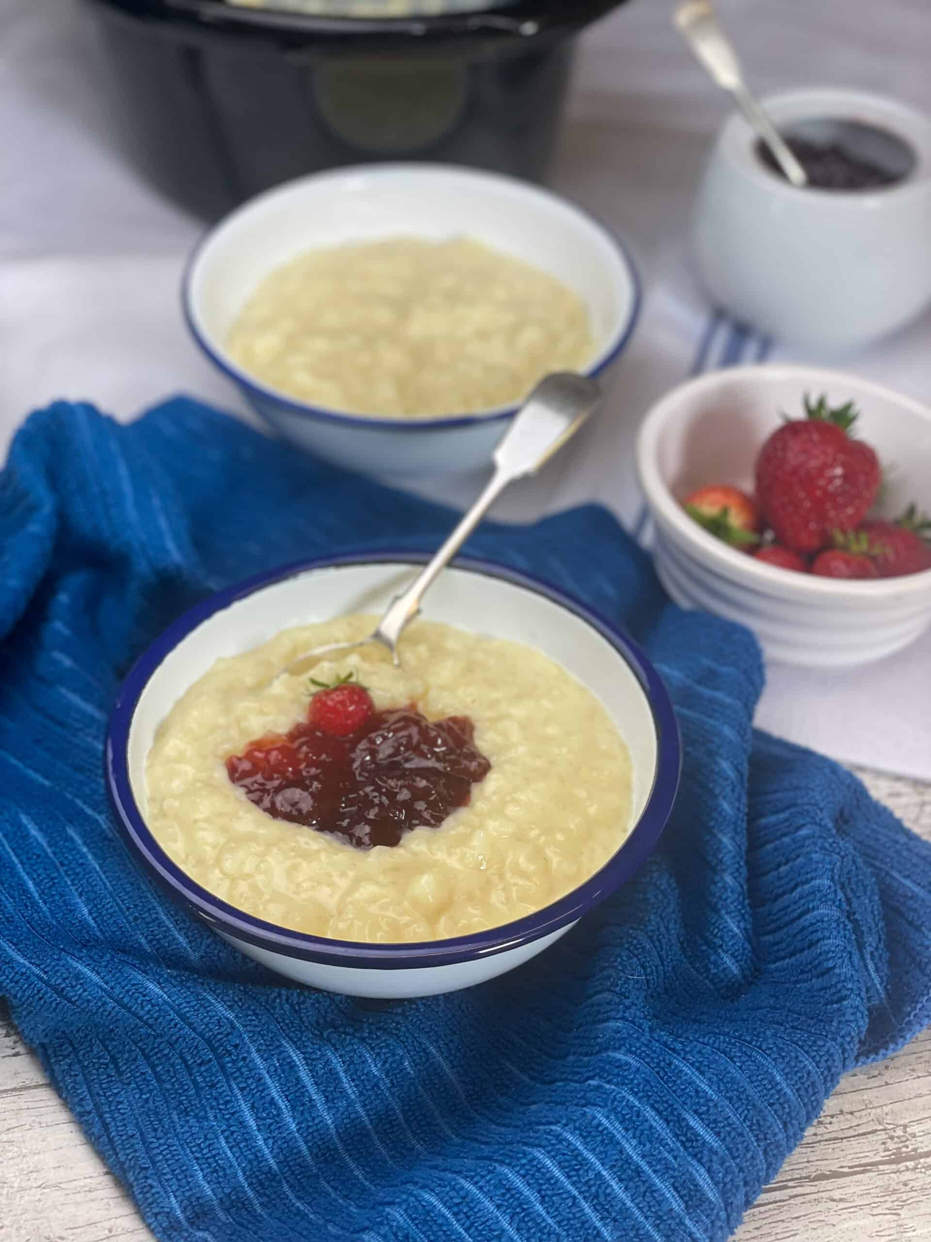 A bowl of rice pudding on a blue tea towel.