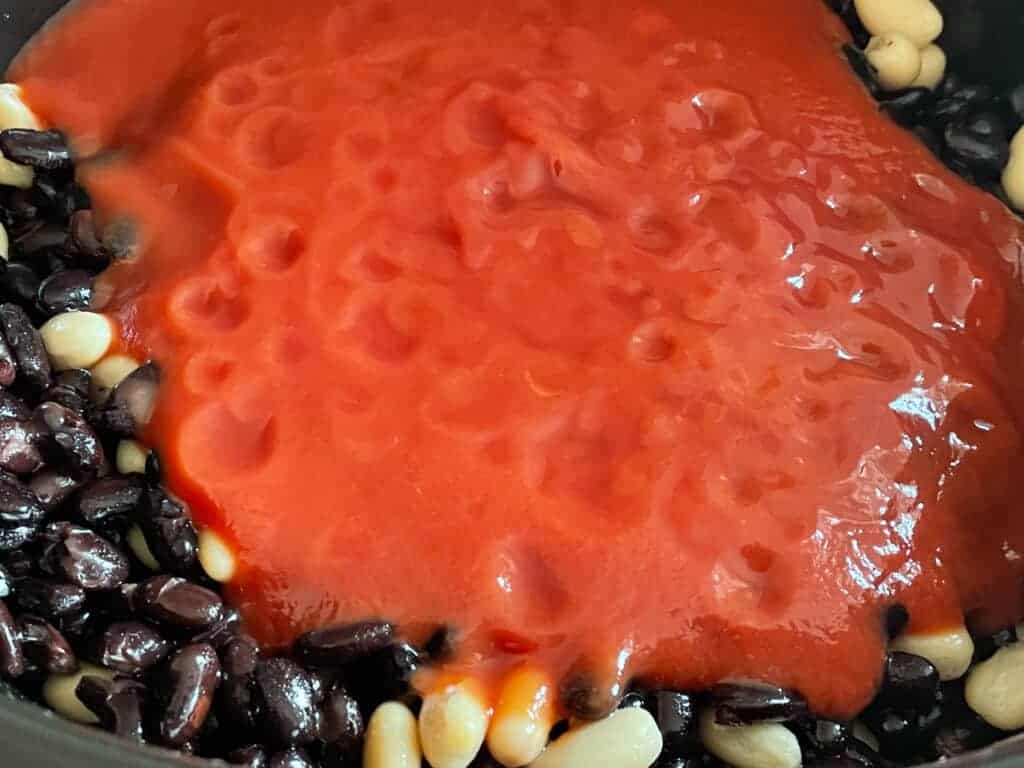 Passata added to the black beans and kidney beans.