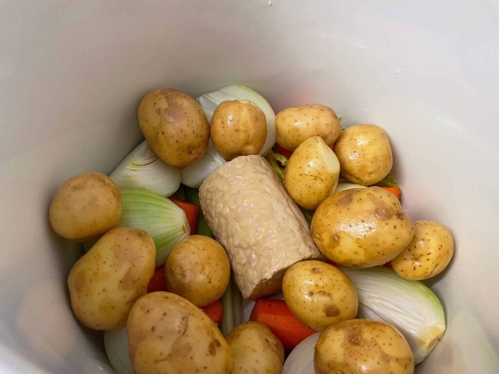 Whole potatoes added to stew in stock pot.